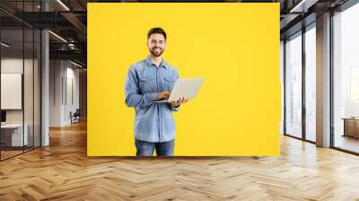 Male programmer with laptop on color background Wall mural