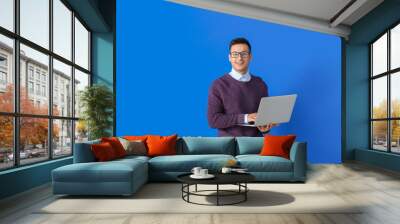 Male programmer with laptop on color background Wall mural