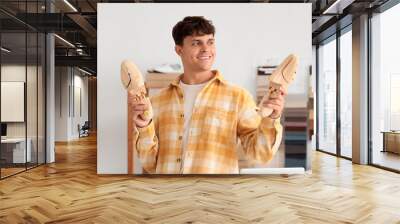 Male shoemaker with shoe trees in repair shop Wall mural