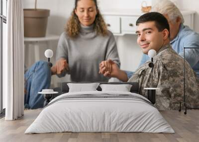 Male soldier praying at group therapy session Wall mural