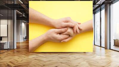 Man holding hand of young woman on color background Wall mural