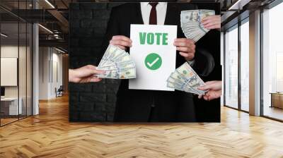 Man selling his vote on dark background. Corruption concept Wall mural