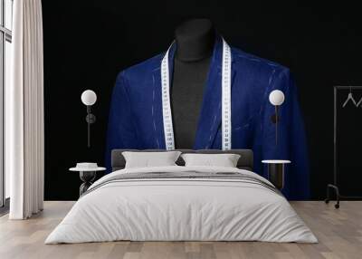 Mannequin with half-finished jacket and measuring tape on dark background Wall mural