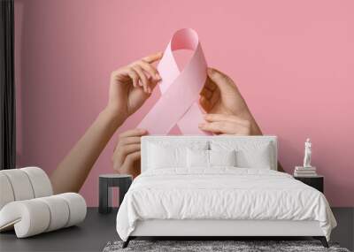 Many female hands with pink ribbon on color background. Breast cancer awareness concept Wall mural