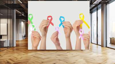 Many hands holding different ribbons on grey background. World Cancer Day Wall mural