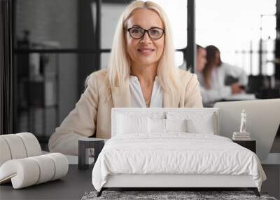 Mature bank manager working at table in office Wall mural