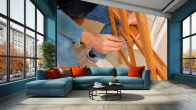 Mature carpenter working with wooden easel in shop, closeup Wall mural