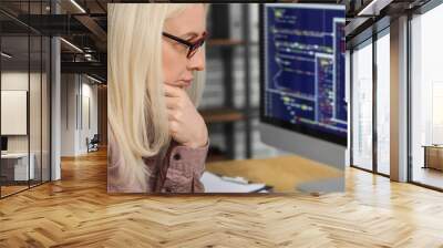 Mature female programmer working with computer at table in office, closeup Wall mural