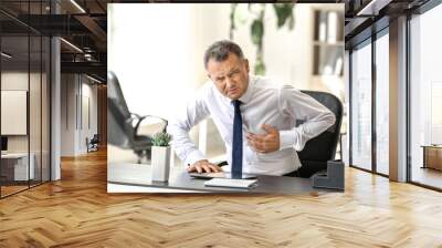 Mature man suffering from heart attack in office Wall mural