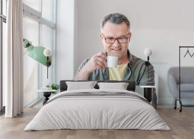 Mature man using laptop at home Wall mural