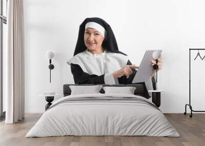 Mature nun with tablet computer on white background Wall mural