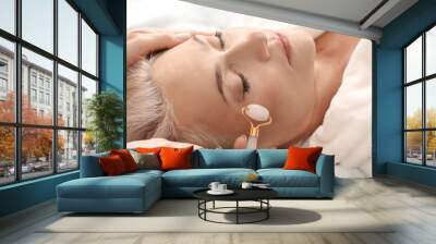 Mature woman receiving face massage in beauty salon Wall mural