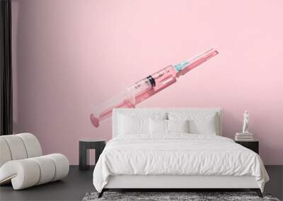 Medical syringe with remedy on pink background Wall mural