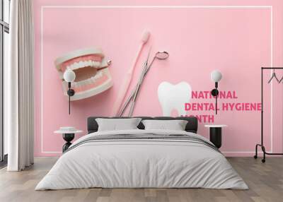 Model of jaw with toothbrush and dentist's tools on color background. National Dental Hygiene Month Wall mural