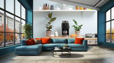 Modern coffee machine, cups and croissants on kitchen table Wall mural