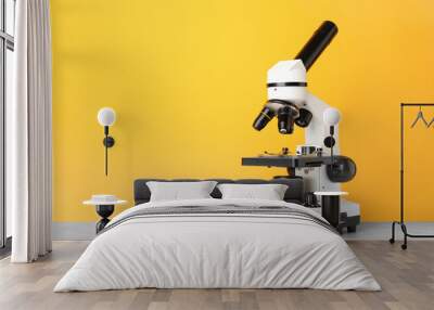 Modern microscope on table against color background Wall mural