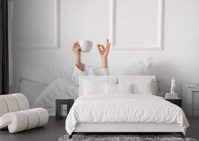 Morning of young woman drinking tea in bed Wall mural