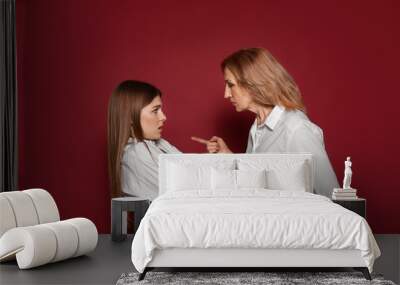 Mother scolding her daughter on color background Wall mural