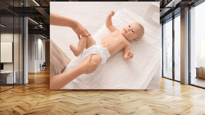 Mother with little cute baby in diaper on changing table at home Wall mural