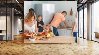 Mother with little daughter cooking in kitchen Wall mural