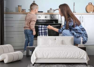 Mother with son cooking together in kitchen Wall mural