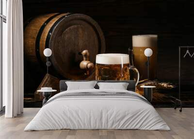 Mug of cold beer and wooden barrel on dark background Wall mural