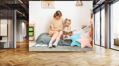 Nanny with little girl reading story in bedroom Wall mural