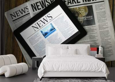 Newspapers, tablet computer and phone with news on screen on wooden table Wall mural