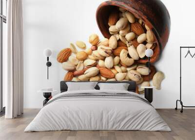 Overturned bowl with scattered nuts on white background Wall mural