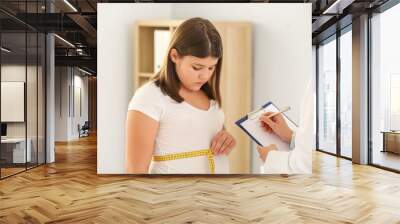 Overweight girl visiting nutritionist in clinic Wall mural