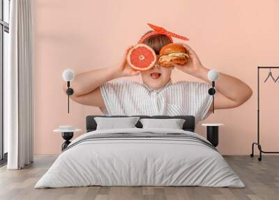 Overweight girl with healthy and unhealthy food on color background Wall mural