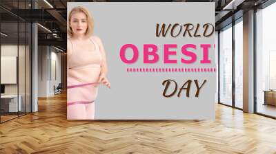 Overweight woman with measuring tape on grey background. World Obesity Day Wall mural