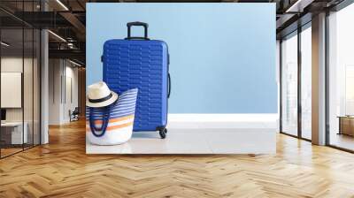 Packed suitcase and beach bag near color wall Wall mural