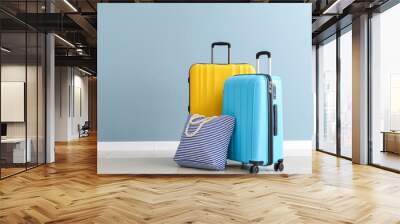 packed suitcases and beach bag near color wall Wall mural