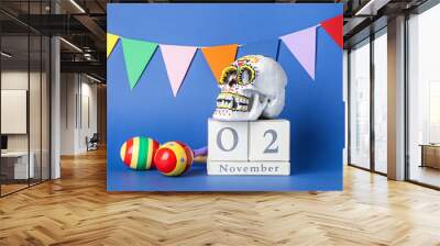 Painted human skull for Mexico's Day of the Dead (El Dia de Muertos), calendar, maracas and garland on color background Wall mural