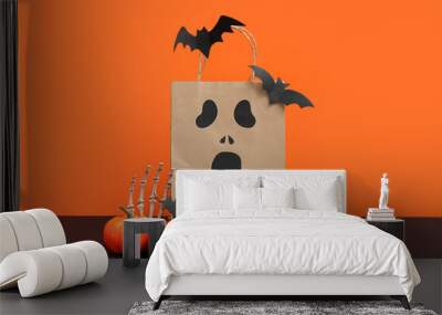 Paper shopping bag and decorations for Halloween on dark table against color background Wall mural