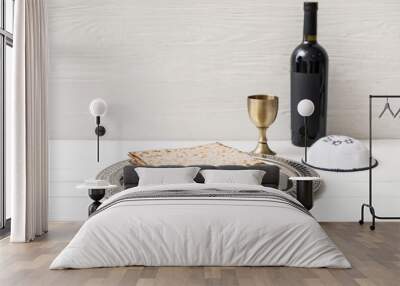 Passover Seder plate with matzo, Jewish cap and wine on table Wall mural