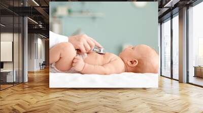 Pediatrician examining cute baby in clinic Wall mural