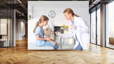 Pediatrician giving medicine to little girl in clinic Wall mural