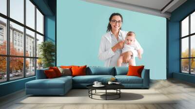 Pediatrician with cute little baby on color background Wall mural