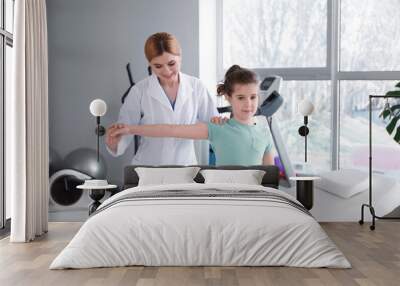 Physiotherapist working with little girl in rehabilitation center Wall mural