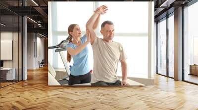 Physiotherapist working with mature patient in rehabilitation center Wall mural