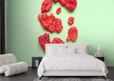 Pieces of fresh raspberries on green background Wall mural