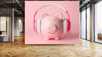 Piggy bank with headphones on color background Wall mural