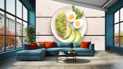 Plate of tasty bruschetta with avocado on light wooden background Wall mural