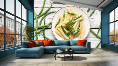 Plate of tasty pasta with green beans on light wooden background Wall mural