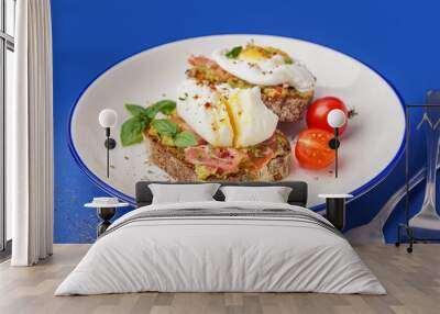 Plate of tasty sandwiches with egg on blue background Wall mural