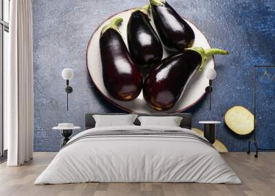 Plate with fresh eggplants on blue background Wall mural