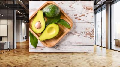 Plate with fresh ripe avocados on white wooden background Wall mural