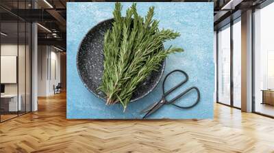 Plate with fresh rosemary on color table, top view Wall mural